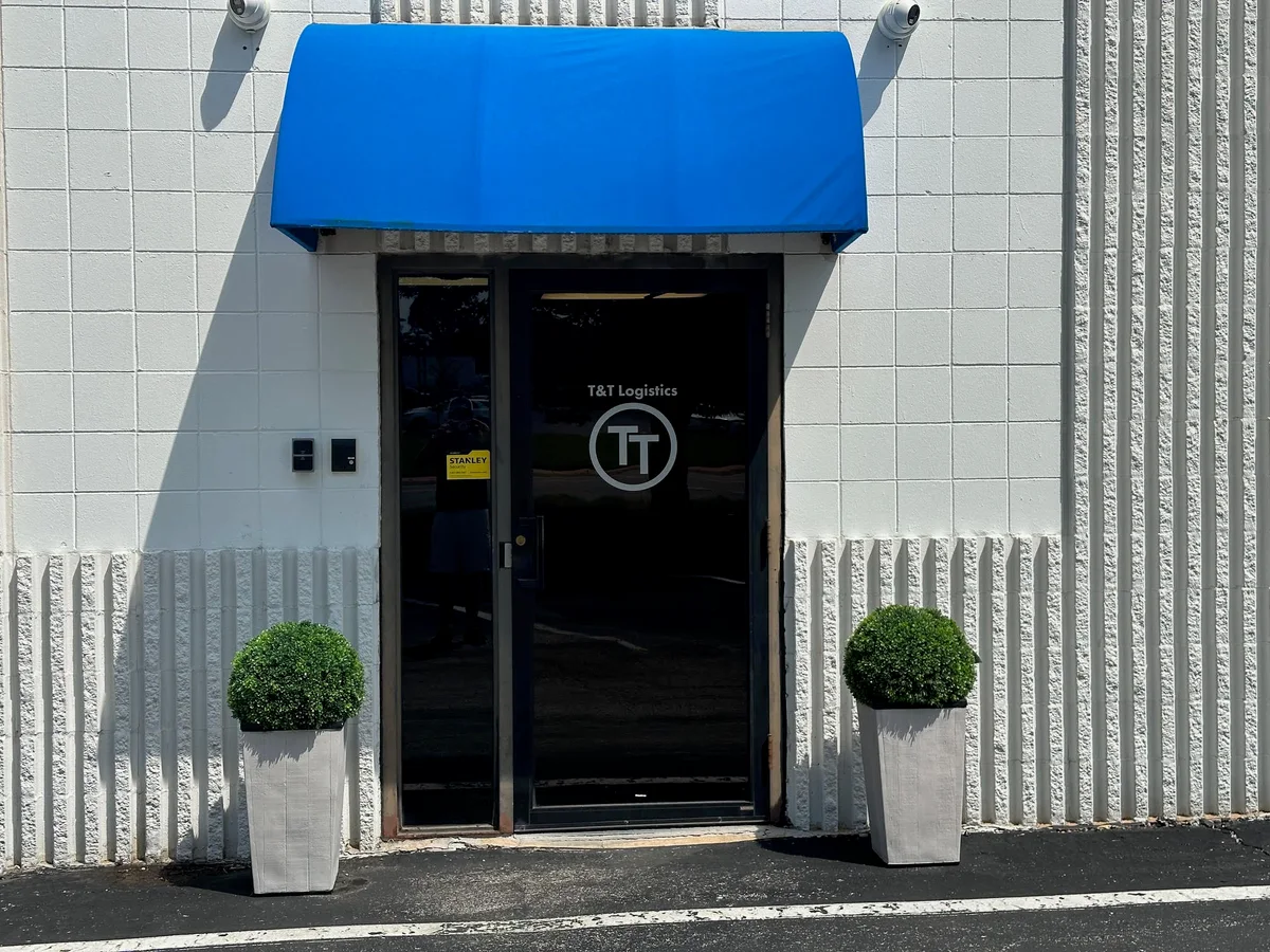 The T&T Logistics office entrance with company branding and a blue awning
