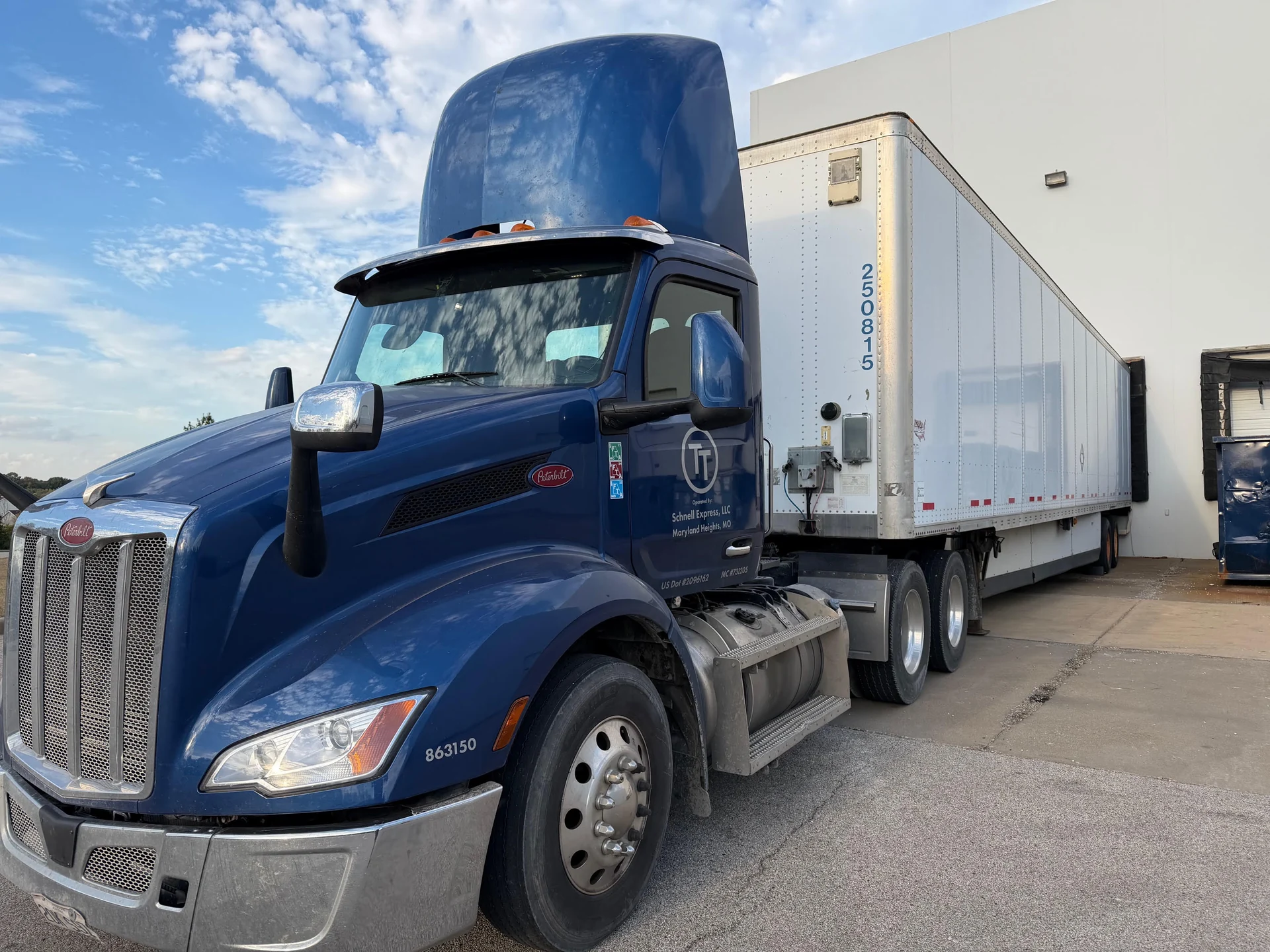 A blue T&T freight truck at a loading dock